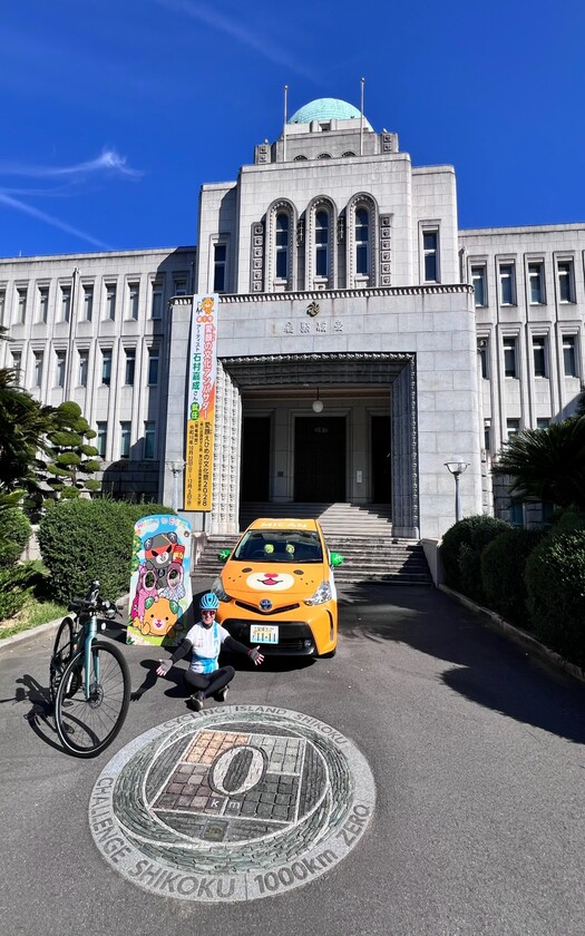 山海戀單車車友在愛媛縣廳前的「四國一周0 km」地標合影。